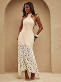 Full front view of ivory halter maxi dress with dotted flared skirt and asymmetric handkerchief hem