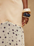 Close-up of fitted ivory waist seam and curved diagonal join to dotted lightweight skirt
