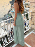 Back view of mint green open-back tie spaghetti strap maxi dress at seaside balcony