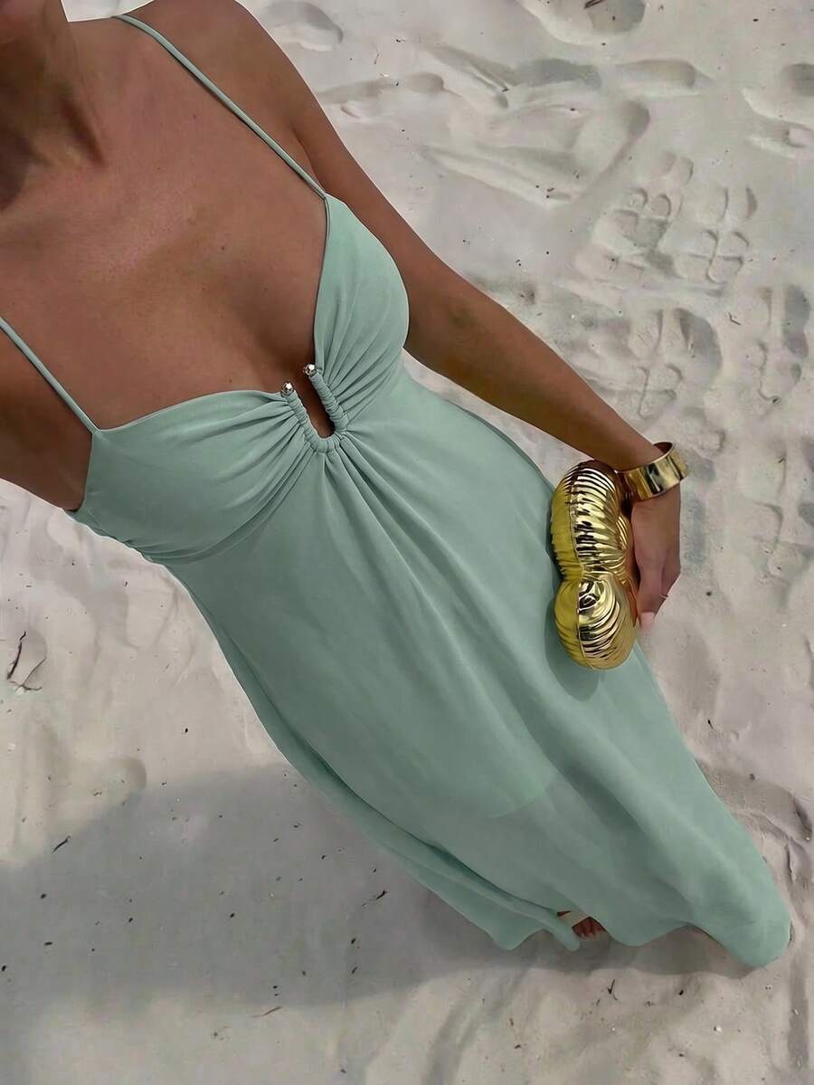 Front view of mint green spaghetti strap gathered bodice maxi dress on balcony