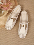 Overhead pair of ivory woven women’s flats with gold floral ornaments and tassel fringe