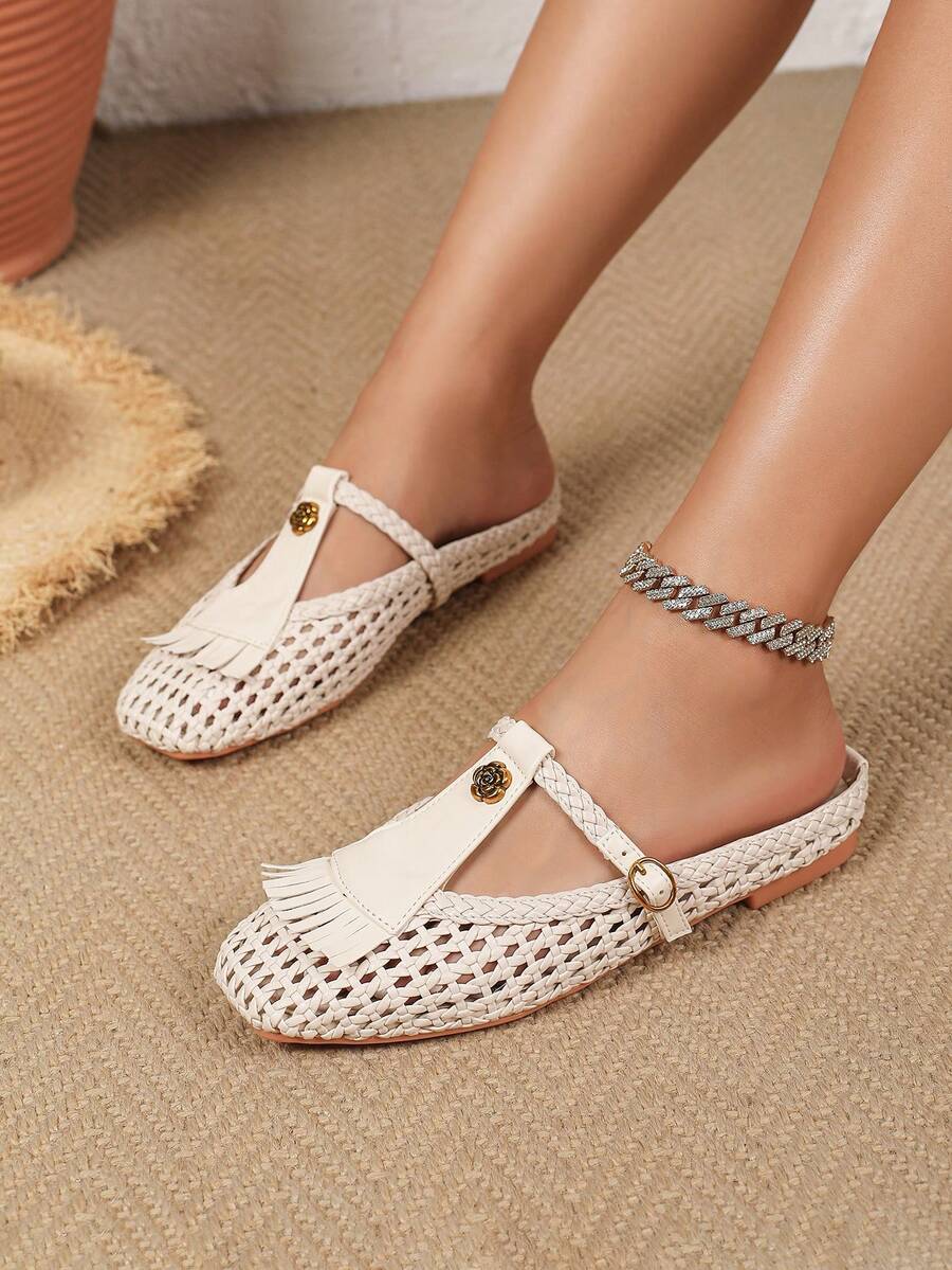 Side on-foot view of ivory woven Mary Jane flat showing buckle strap and low sole