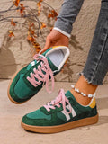 Overhead side view of green retro sneakers with white stripes and bright pink laces