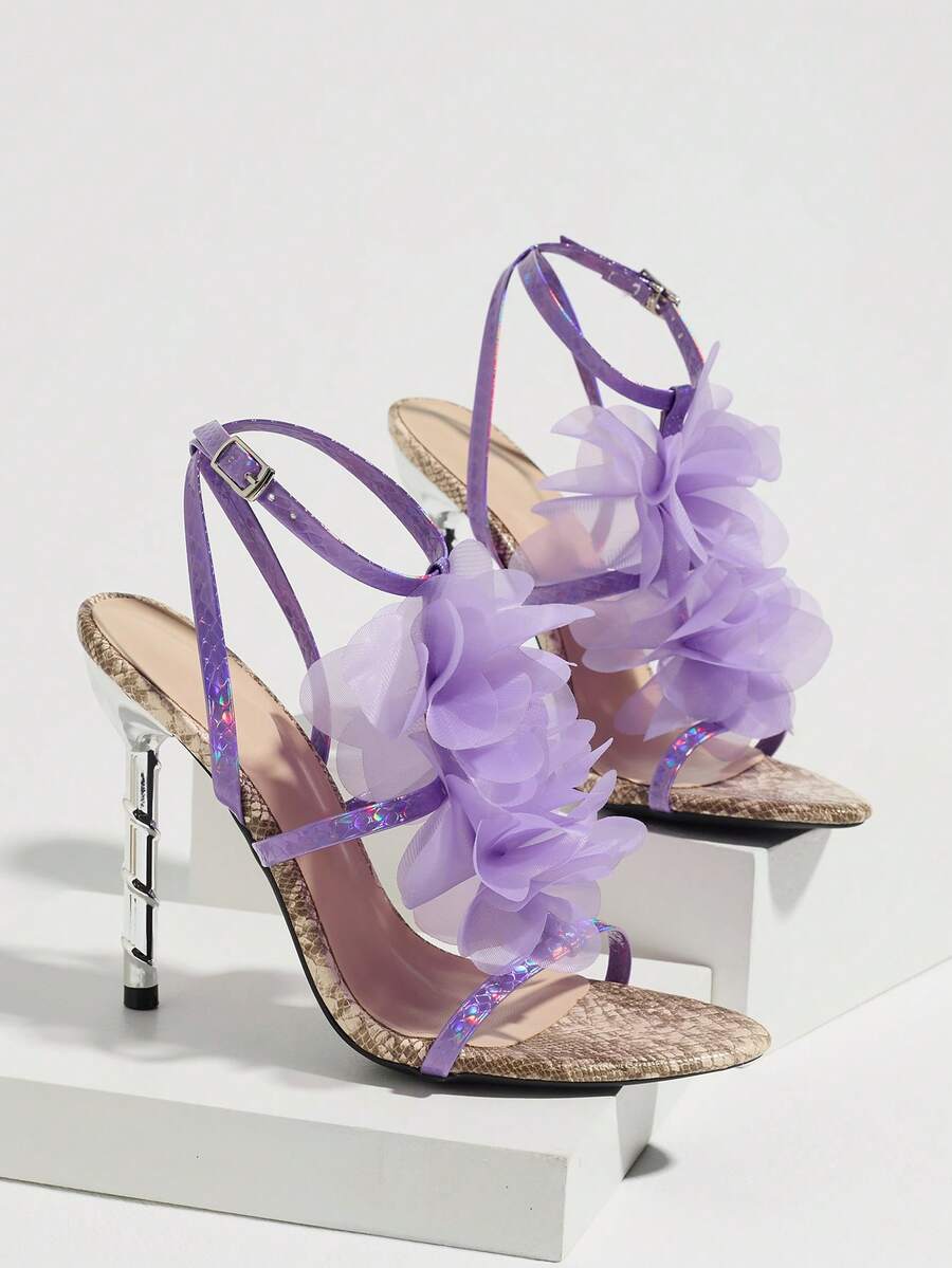 Studio display view of lavender snakeskin 3D floral cross-strap square-toe stiletto sandals with metallic heel
