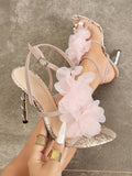 Handheld front view of baby pink snakeskin 3D floral cross-strap square-toe stiletto sandals with metallic heel