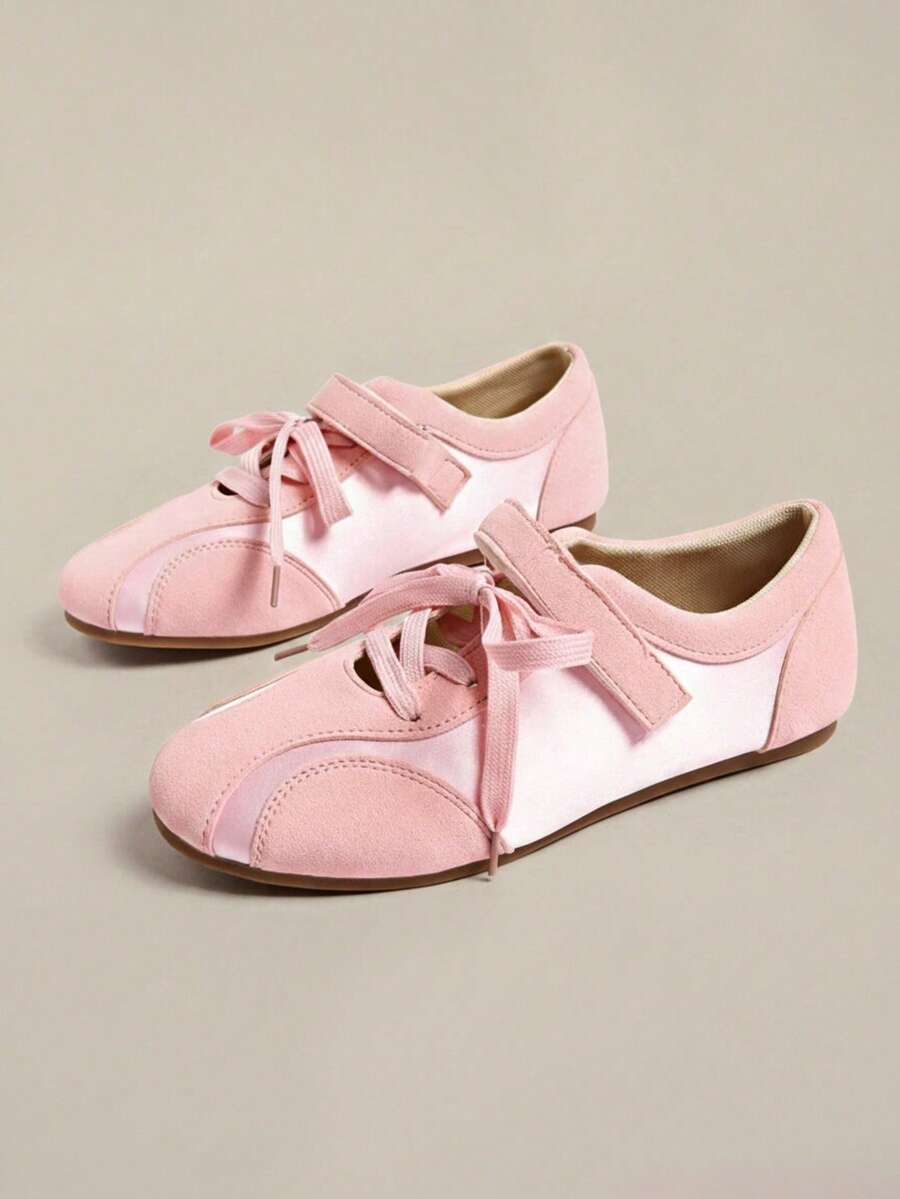 Pair of pale pink low-top sneakers with laces, hook-and-loop straps, and flat brown gum soles