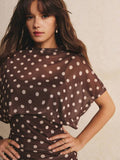 Close-up of brown mini dress neckline and semi-sheer polka-dot batwing sleeve