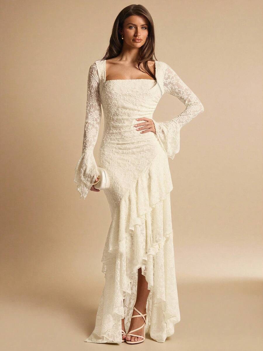 Full front view of an ivory square-neck lace maxi dress with hand on hip and an asymmetric cascading ruffle skirt