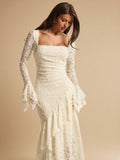 Close front view of an ivory lace dress showing the square neckline, ruched waist and long flared sleeve cuffs