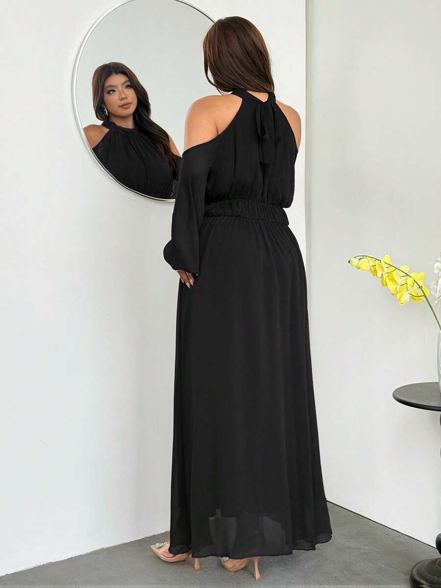 Back view of black halter tie-back maxi dress with sheer hem