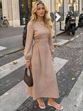 Full front street view of taupe striped maxi dress with round neck and flowing flared skirt