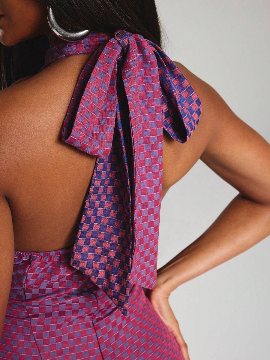 Close-up back view of tie straps and open back on pink purple and navy plaid halter mini dress