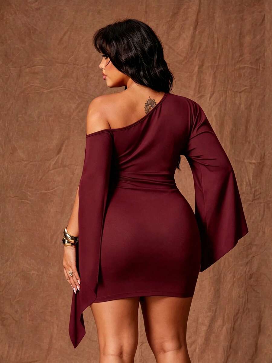 Rear view of burgundy fitted mini dress with asymmetrical neckline and flowing sleeve panels