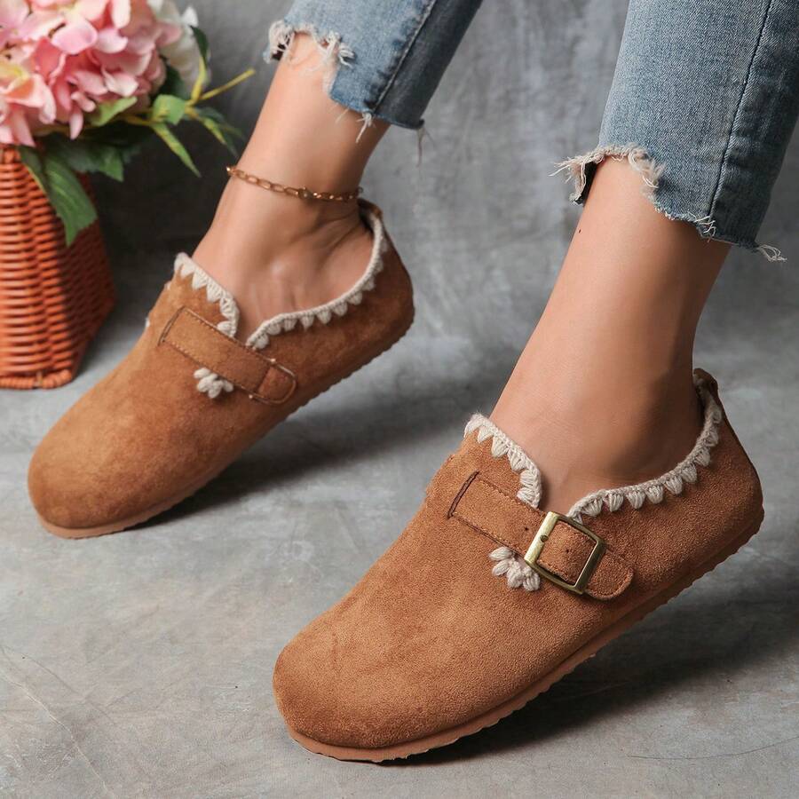 Front three-quarter view of camel round-toe buckle loafers worn with jeans