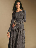 Back view of the black and cream striped maxi dress showing horizontal stripes on the bodice and vertical stripes on the skirt