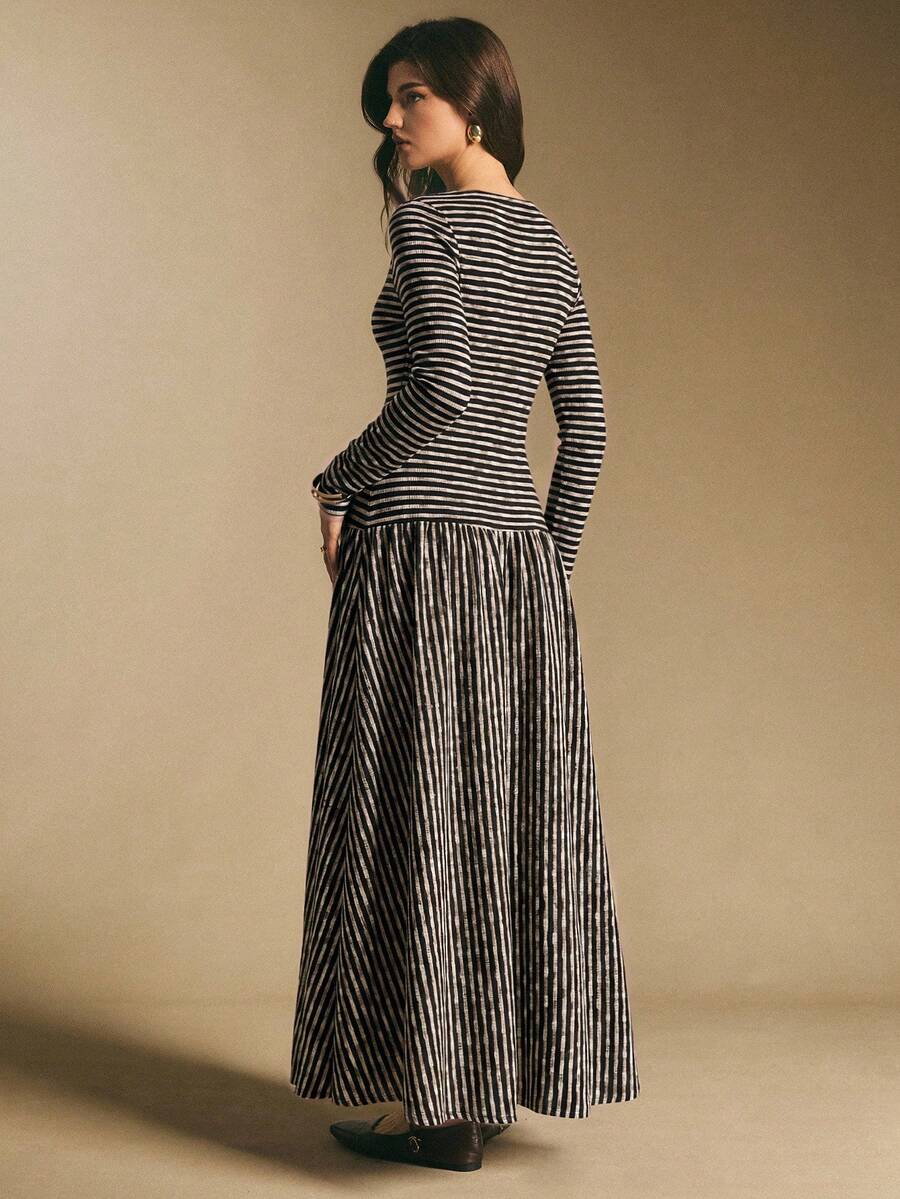 Close front view of the black and cream striped maxi dress showing button placket and long sleeves