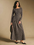 Front view of a black and cream striped long-sleeve maxi dress with horizontal bodice stripes and vertical skirt stripes