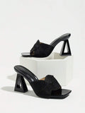 Black woven bow vamp square-toe mule pair with hollow trapezoid heels