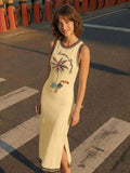 Elevated front view with side slit of butter yellow tropical toucan maxi dress by waterfront