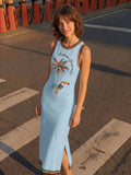 Elevated front view with side slit of baby blue tropical toucan maxi dress by waterfront