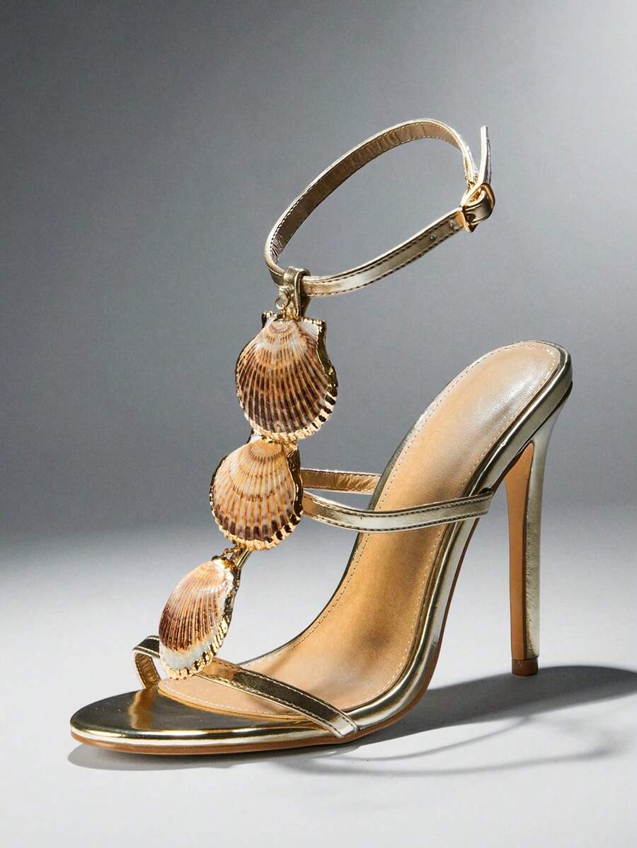 Side product view of metallic gold scallop-shell T-strap square-toe stiletto sandals with ankle buckle for beach party styling
