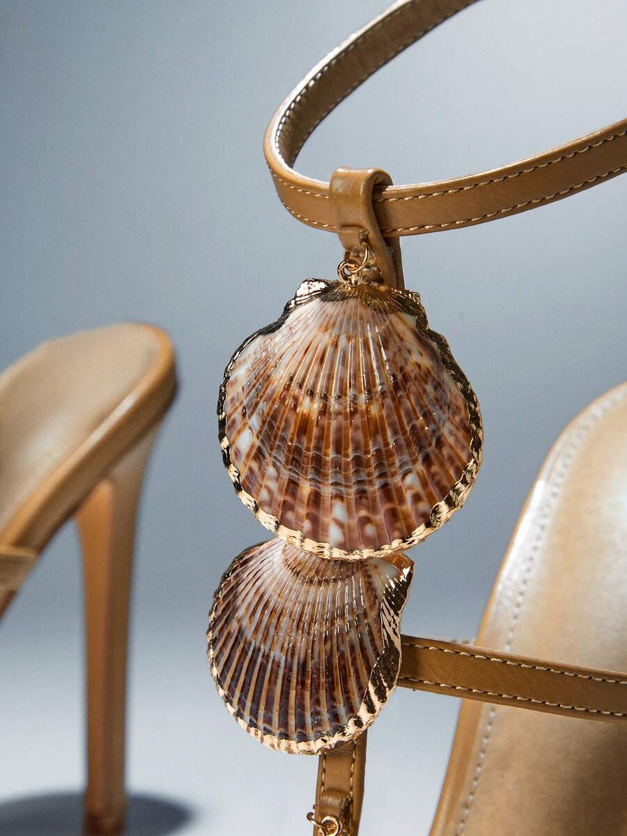 Shell detail close-up of khaki scallop-shell T-strap square-toe stiletto sandals with ankle buckle for beach party styling