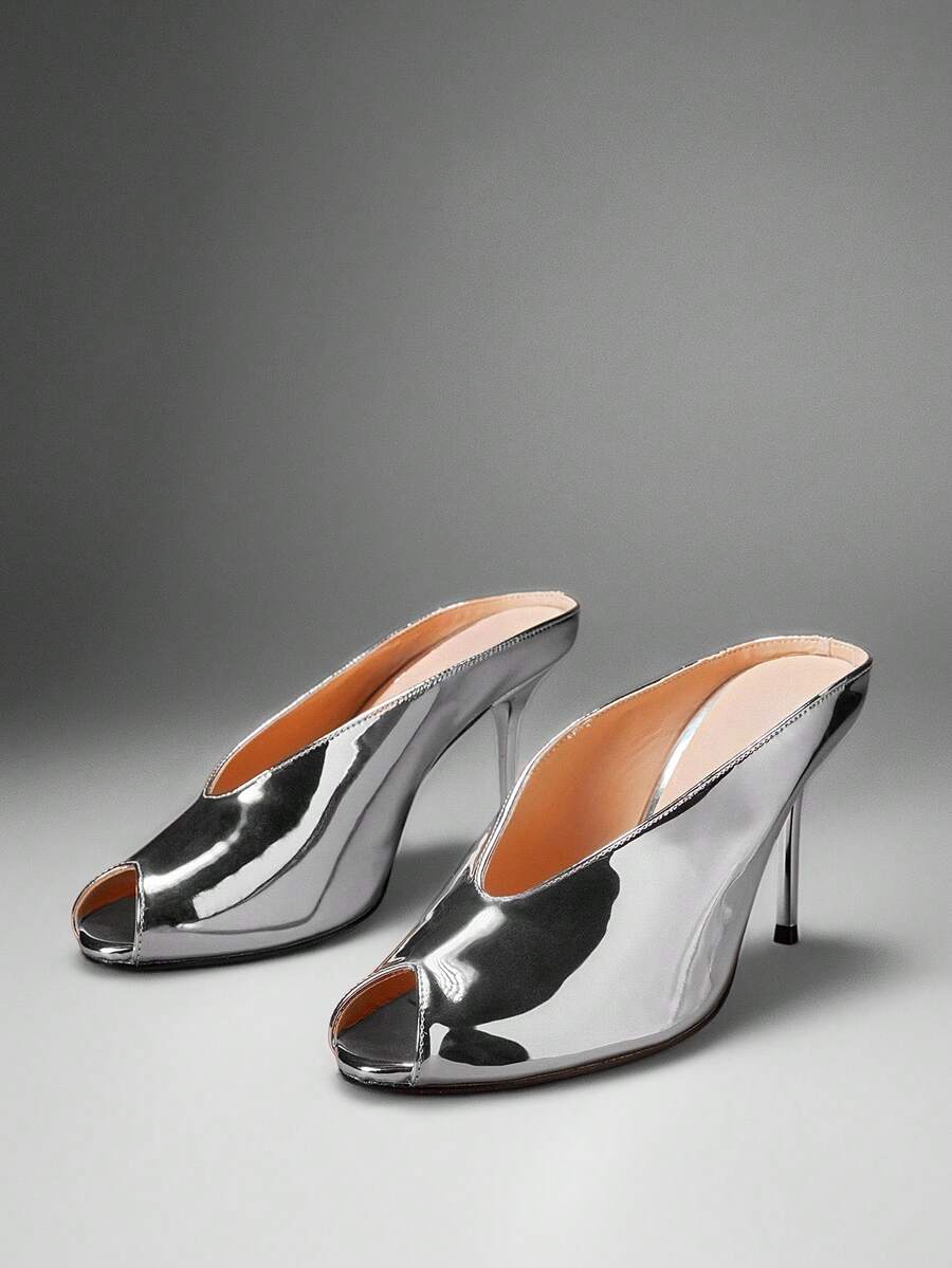 Silver front three-quarter product view of peep-toe stiletto mule sandals with a backless slip-on upper and slim high heel