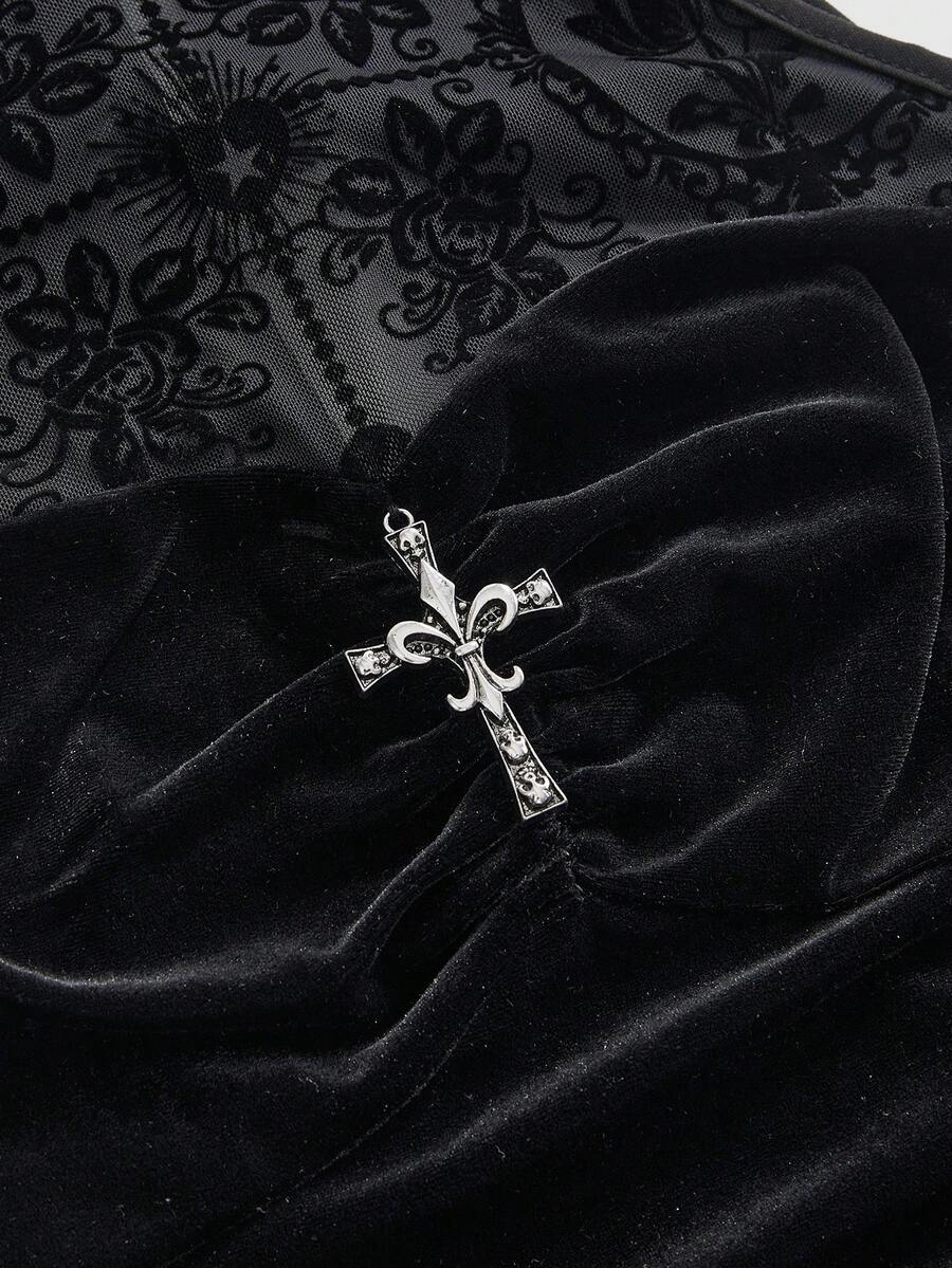 Close-up of black velvet-look bodice with silver-tone cross ornament and flocked mesh