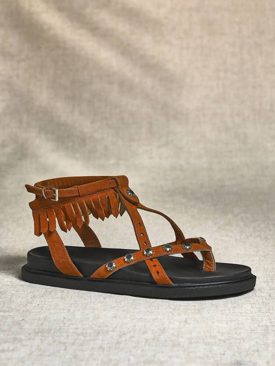Side view of chestnut boho fringe ankle-strap sandal with black thick sole