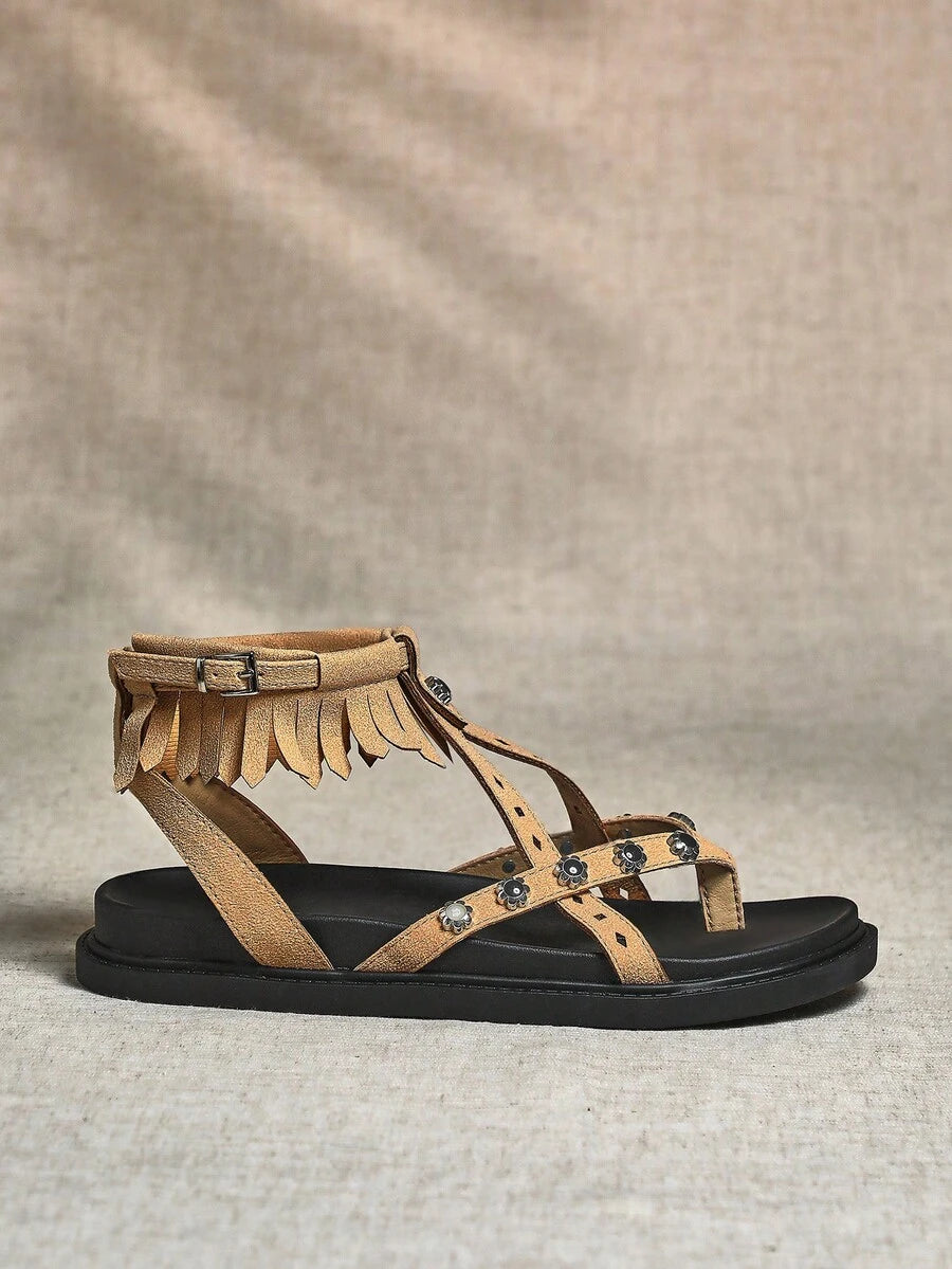 Side view of beige boho fringe ankle-strap sandal with black thick sole