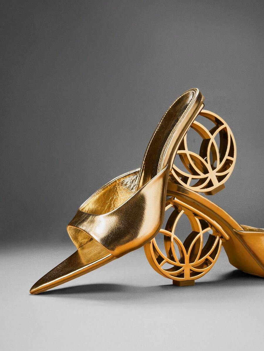 Gold pointed open toe mule heels with wide metallic vamp in studio