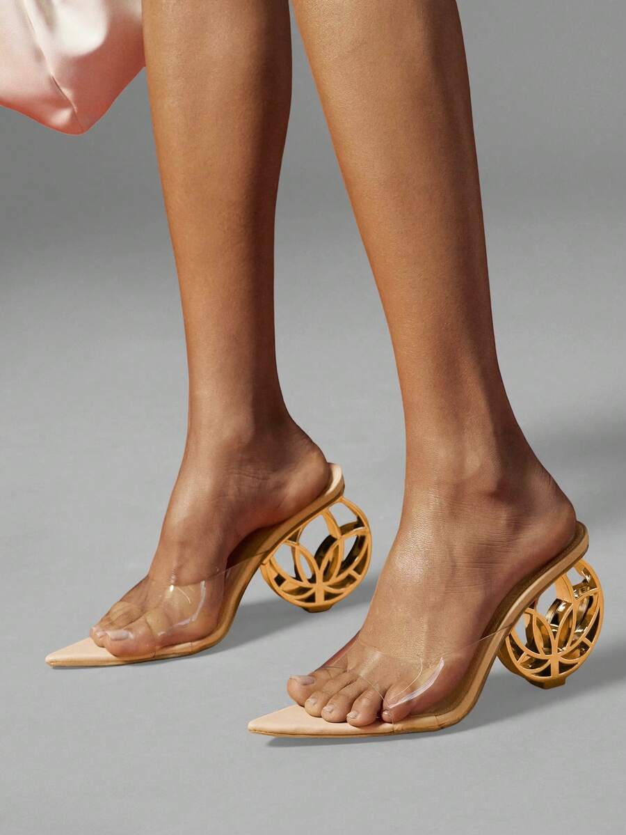 Close view of nude clear vamp pointed mule heels with gold wheel heel