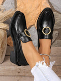 Top-front view of black block heel loafers with gold-tone oval rhinestone buckles