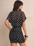 Rear view of black dotted mini dress showing batwing overlay and gathered short skirt