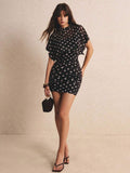 Close-up of black polka-dot dress high neckline and semi-sheer batwing sleeve detail