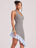Three-quarter view of black and white gingham halter mini dress with fitted silhouette and high-low hem