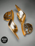 Overhead product view of metallic gold open-toe mule sandals with wide vamp and hollow circular sculptural heel