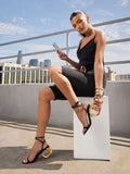Black ankle strap open toe sandals with gold circular heel worn outdoors