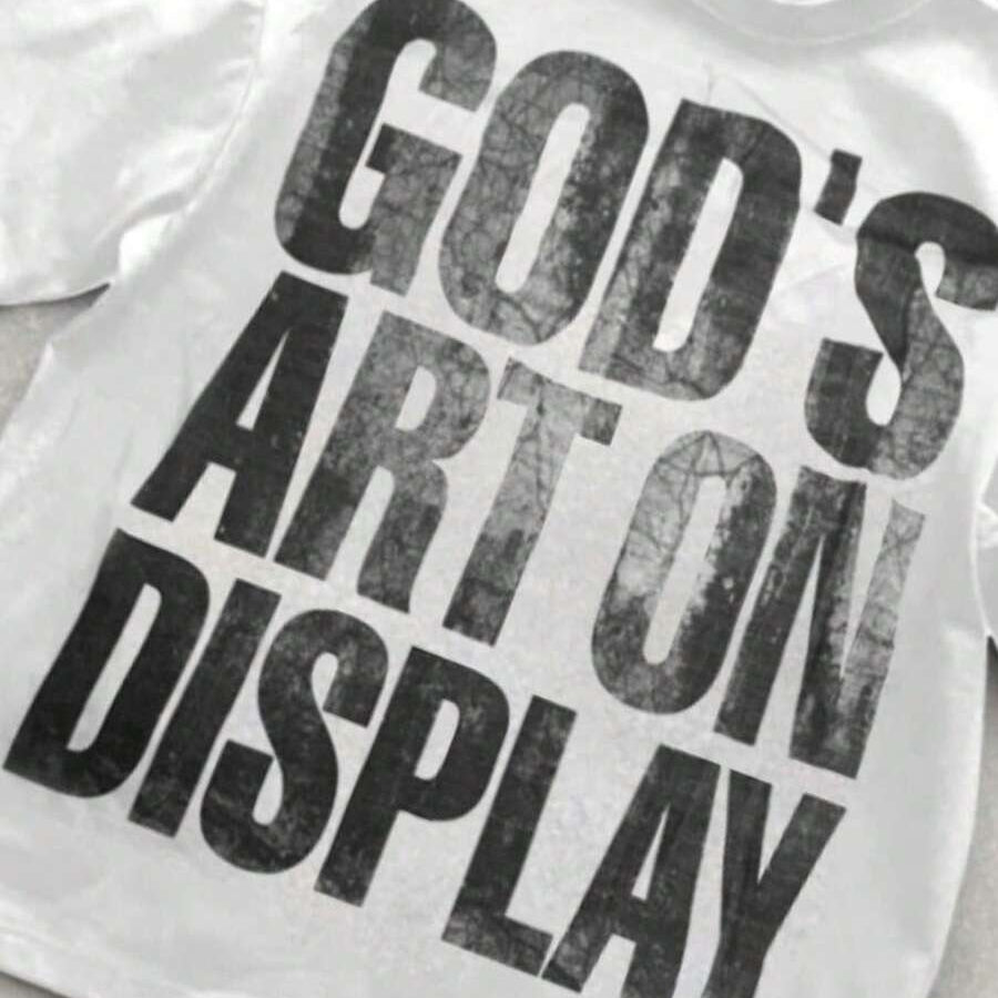 Close view of God’s Art On Display graphic on white T-shirt