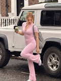 Full-length view of pastel pink flared-leg jumpsuit styled with sneakers for casual streetwear