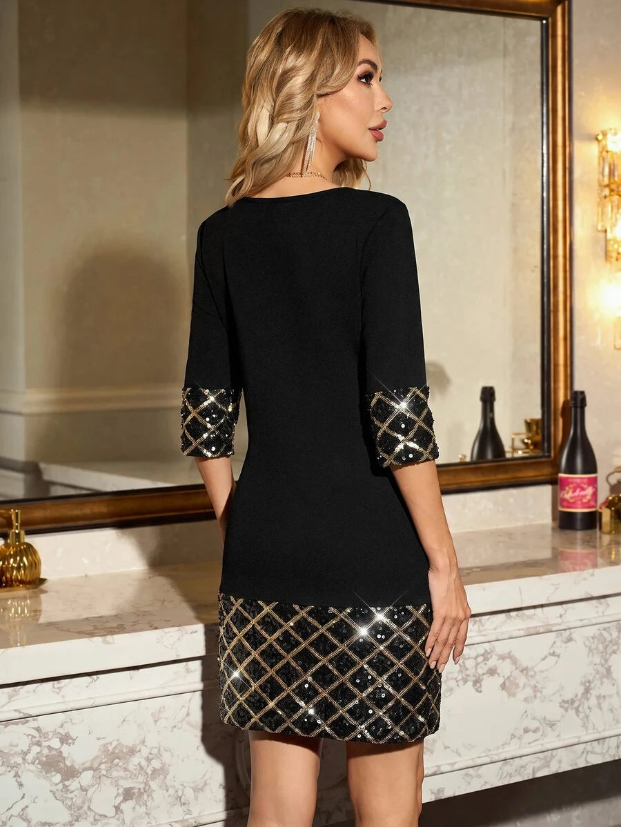 Front view of black short tunic dress with gold lattice sequin cuffs and hem