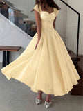 Front Full-Length View of pale yellow colorblock A-line midi dress with cap sleeves for wedding guest styling