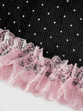 Close view of pink ruffled lace trim along black polka dot mini dress hem