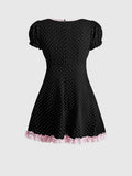 Back view of black polka dot puff sleeve mini dress with pink lace hem trim