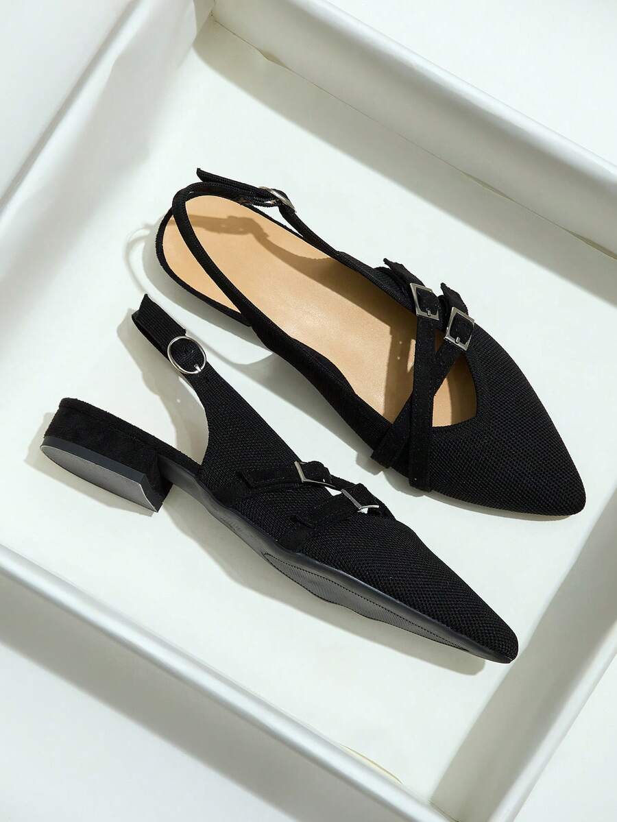 On-foot front view of black pointed-toe double-buckle slingback flats