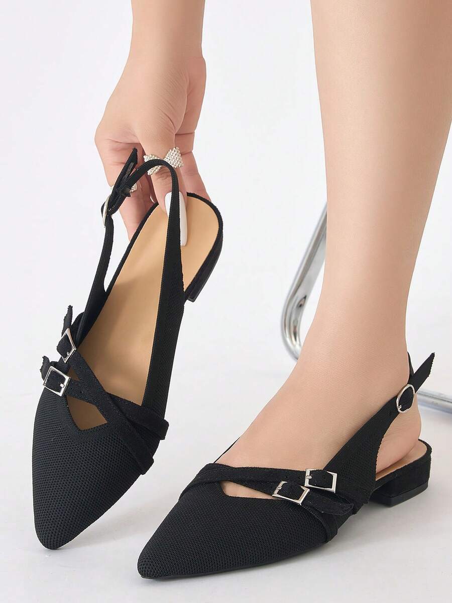 On-foot front view of black pointed-toe double-buckle slingback flats