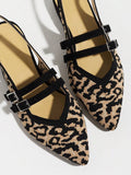 Close-up of textured leopard fabric pointed toe flats with double buckle detail