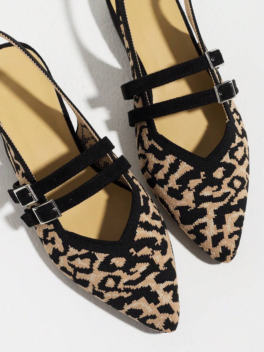 Close-up of textured leopard fabric pointed toe flats with double buckle detail