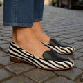On-foot close front view of gold-heart zebra loafers with contrast binding