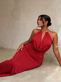 Seated view of red halter evening dress showing draped bodice and ruched waist